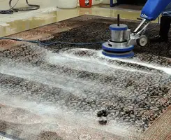 Professional rug cleaning with a rotary floor machine and shampoo foam, deep-cleaning an area rug, in Reno, NV.